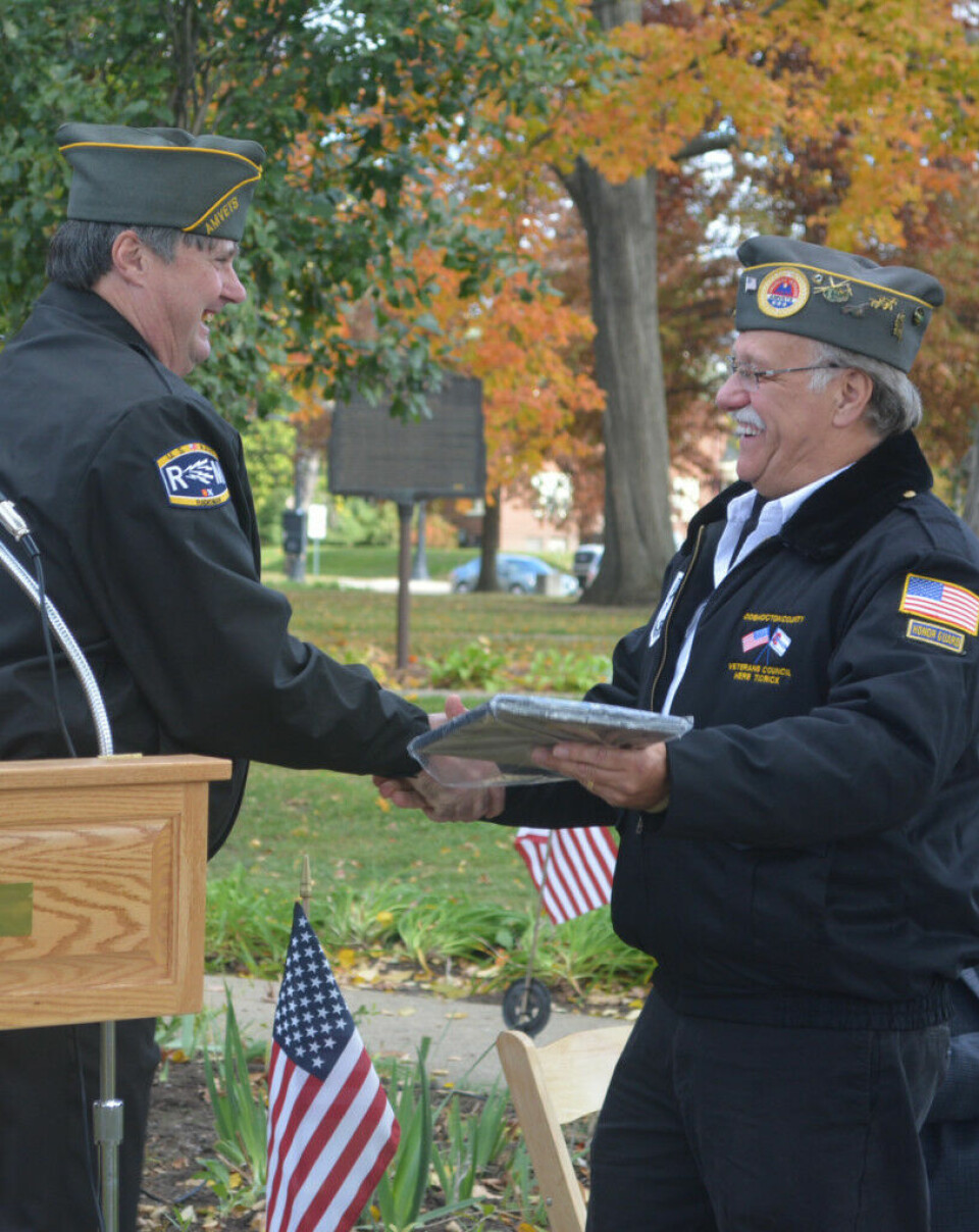 Tidrick encourages people to ask veterans to share their stories Veterans Service Officer Jim Barstow presented Herb Tidrick with a plaque honoring him for his dedication to helping veterans in our community. Tidrick retired from the veterans’ service office on Nov. 11 and was the main speaker at the Veterans Day ceremony on the court square. Both Barstow and Tidrick are veterans of the U.S. Navy. Josie Sellers | Beacon