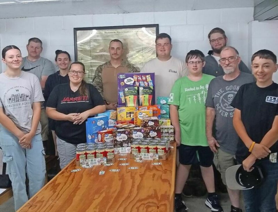 The Holmes County 4-H Shooting Sports Club members, as one of their community service projects, presented nonperishable food items for the Mansfield National Guard Unit to Tanner Neuenschwander, fifth from left, a guard member and past club member. 4-H Shooting Sports Club meets