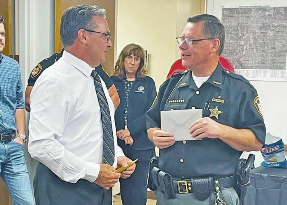 Detective Sergeant Alex Abel, left, is congratulated by Sheriff Travis Hutchinson on his retirement after 26 years of service to the Wayne County Sheriff’s Office. In retirement, Abel plans to keep right on working