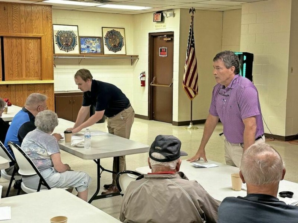 As U.S. Congressman Troy Balderson, right, addresses the crowd of veterans during his visit to Millersburg, his aide Javan Johnson provides information to a previous veteran who had a question. Balderson connects with Holmes veterans over coffee