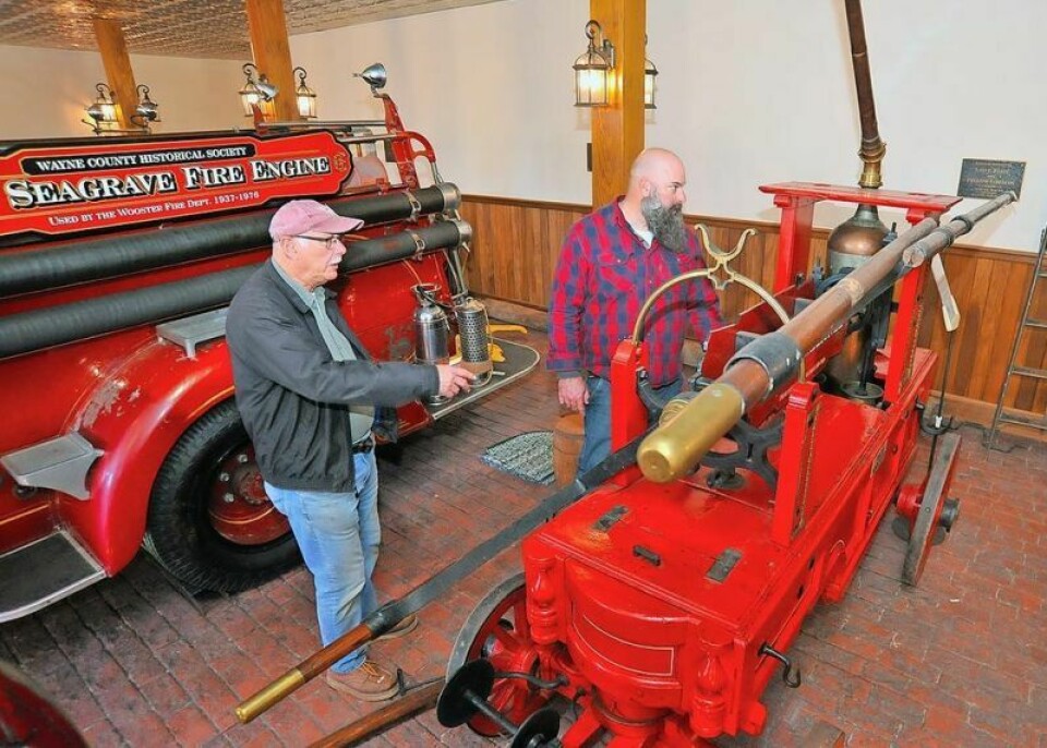 Ray Leisy, left, retired judge and former Wayne County Historical Society president, tells Commissioner Dave McMillen about the fire trucks on display at the historical society. Commissioners dive into local lore on Historical Society tour