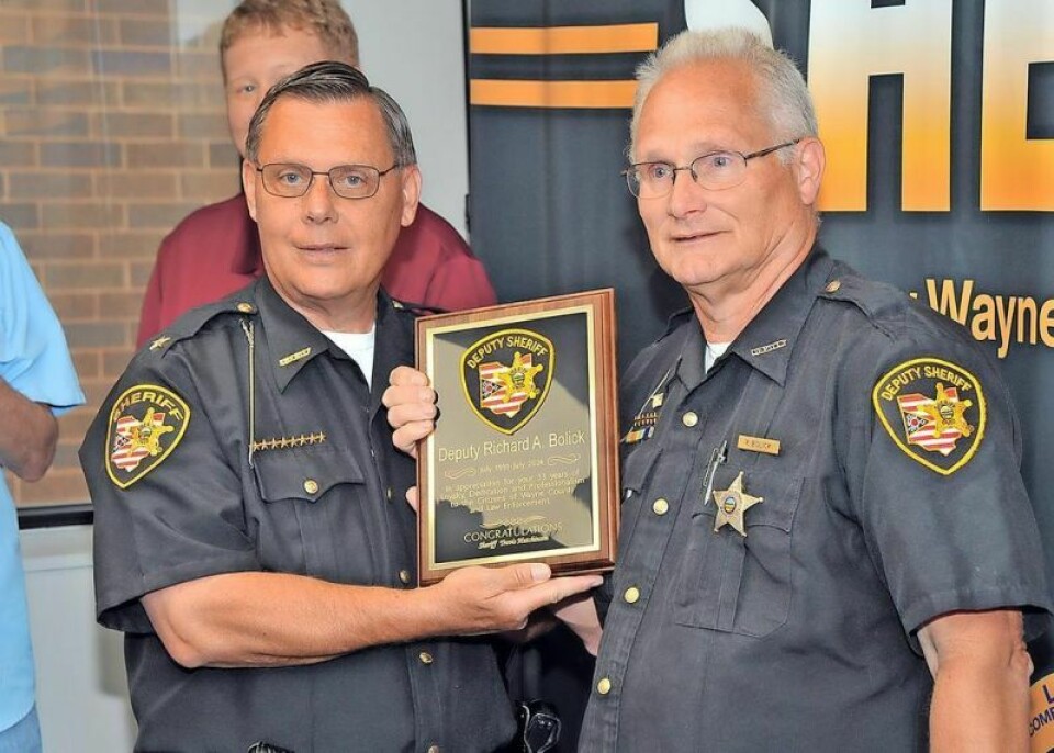 Wayne County Sheriff Travis Hutchinson, left, presents deputy Richard “Rick” Bolick a plaque at his retirement party honoring him for 33 years of service to the sheriff’s office. Bolick retires after 33 years as Wayne County deputy