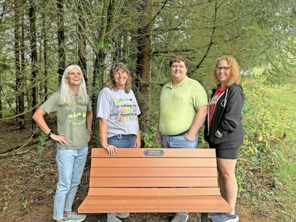 NJC Foundation board members Jami Swartzwelder, left, chairman; Marsha Freeland, vice chairman; Trevor Rentz, treasurer; and Mary Jo Hanlon, secretary, stand with one of the memorial benches. Commemorative benches available at Norma Johnson