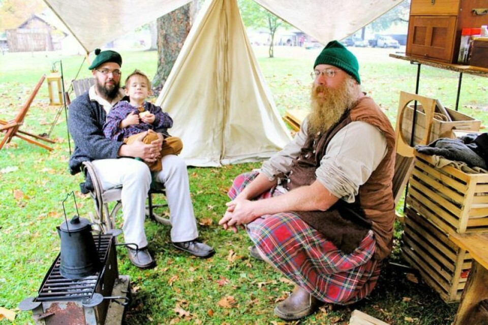 Sean Stevenson, right, of Green with his son Gabriel, 4, and Erik Sweebe of Alliance wait out the rain at Apple Butter Days. Rain didn’t stop Apple Butter Days