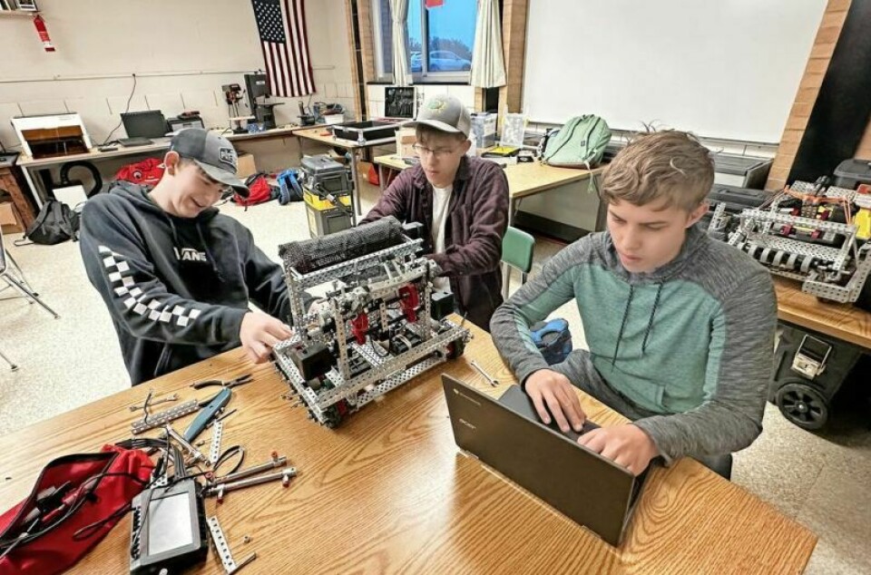 West Holmes High School sophomores Collin Badger, left, and Miles Malasch work on their robot while fellow sophomore Owen Malasch works on coding. Knights have pioneers in the world of robotics