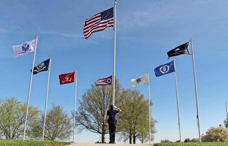 A Wayne County Schools Career Center criminal justice student salutes the flag of the United States at the PFC Eric J. Miller Veterans Memorial Flag Park honoring career center alumni veterans. Career center honors former students with flag park