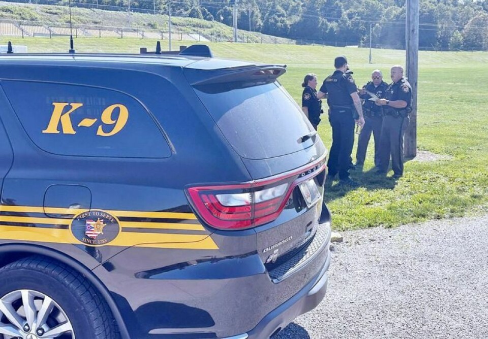 One of the teams of officers participating in Holmes County’s “Operation Blue Light” discusses strategy before heading out to serve warrants for arrest to 14 people connected to drug trafficking in the county. ‘Blue Light Special’ helps round up area drug dealers