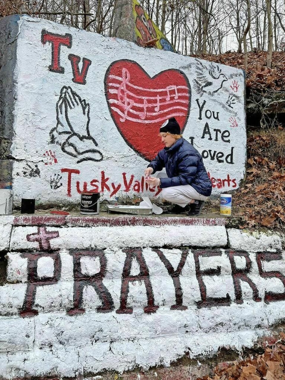 In a touching sign of support, New Philadelphia High School alumnus Lydia Salazar paints the rock along Seven-Mile Drive typically reserved for New Phila's graduating classes. Community comes together to help those affected by recent accident