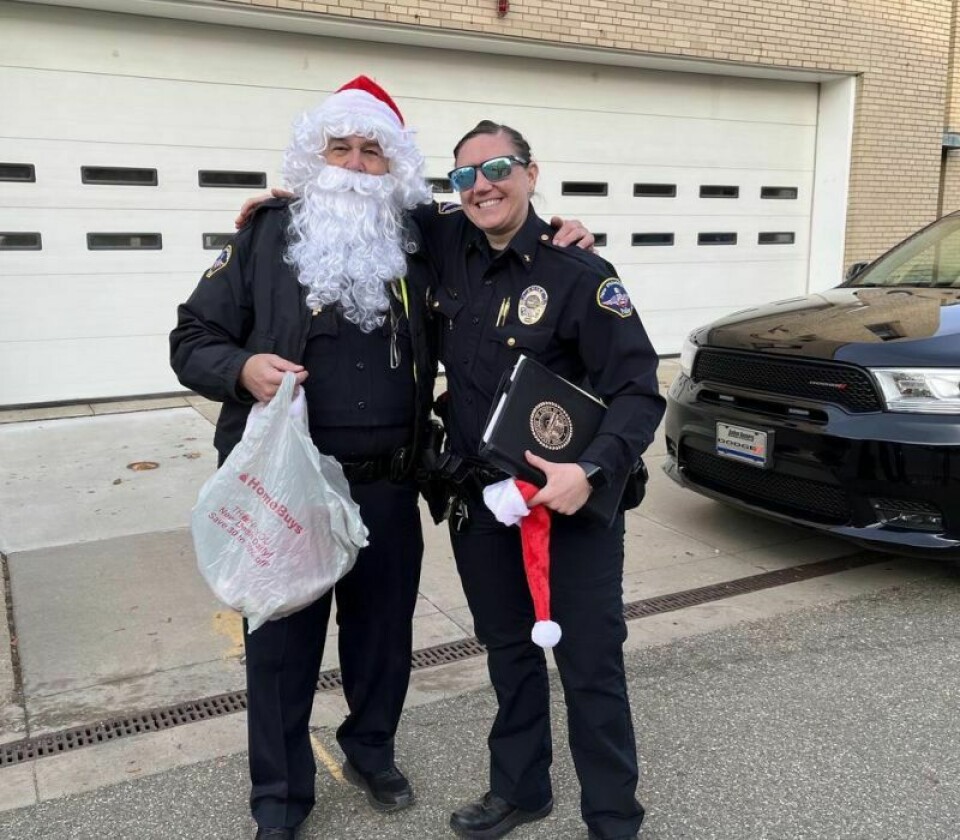 Under that beard is police officer Robert Everett posing with New Philadelphia Chief of Police Tessa Pohovey before joining the Christmas with a Cop caravan of cruisers. Making spirits brighter, a caravan of cops delivers gifts and hope to area families