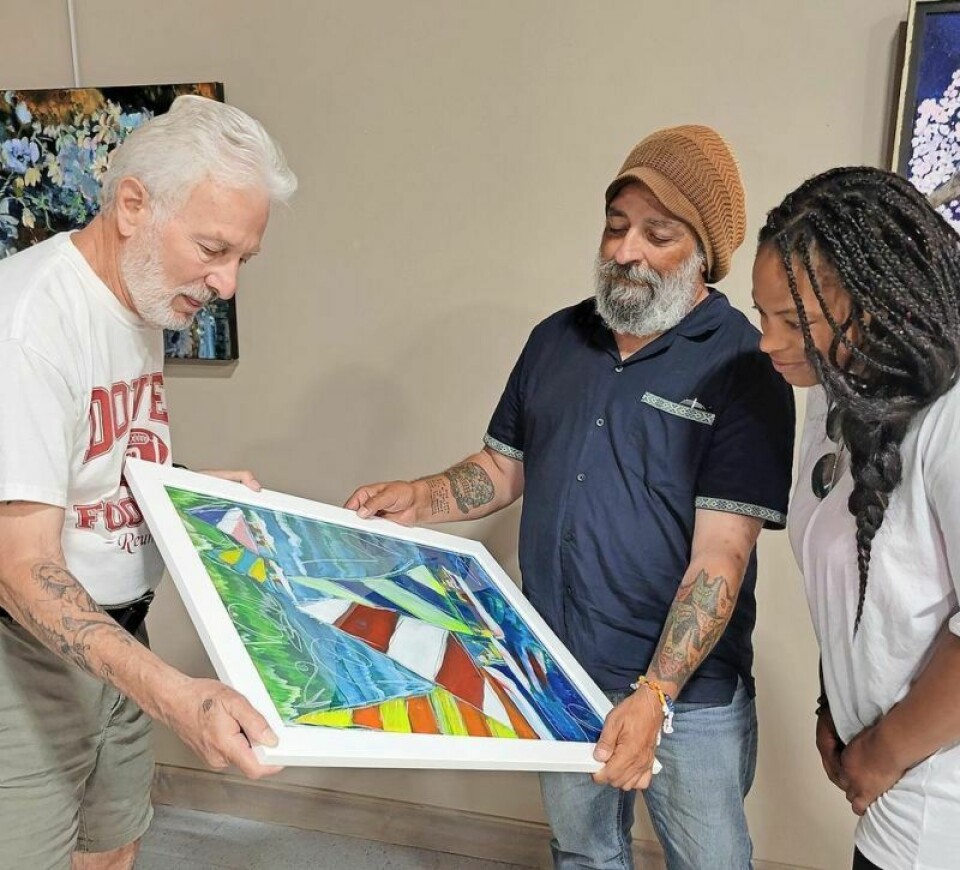 Dave Trustdorf, left, Justin Schilling and Jasmine Mills admire a work by Sarah Dugger. Mid Summer’s Night Art Affair to open at arts center