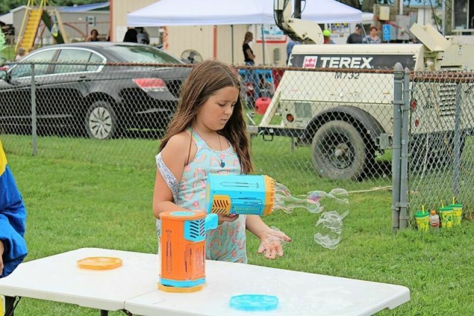 Sophie Curran, 8, of Midvale plays with the bubble guns at Kids Day in 2023. Event celebrates village's 135th anniversary