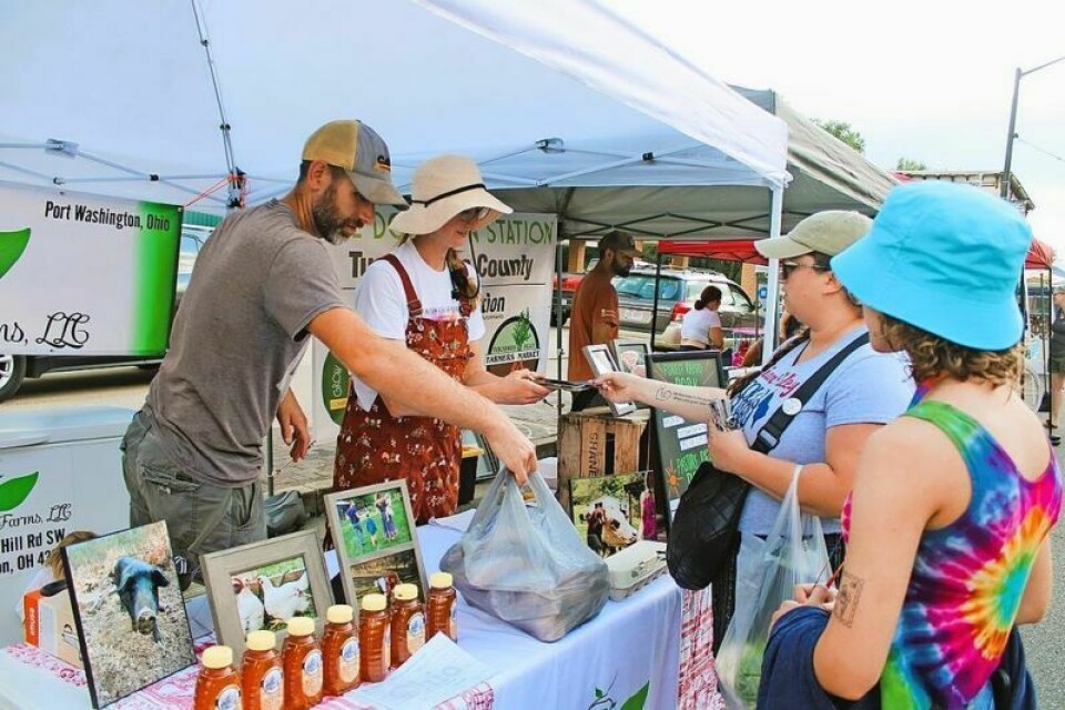 Jonathan, left, and Shana Angel of Angel Family Farms sell some of their farm raised meats to Tabitha Johnson of Gnadenhutten and her daughter, Lily. Uhrichsville Market begins 2024 season