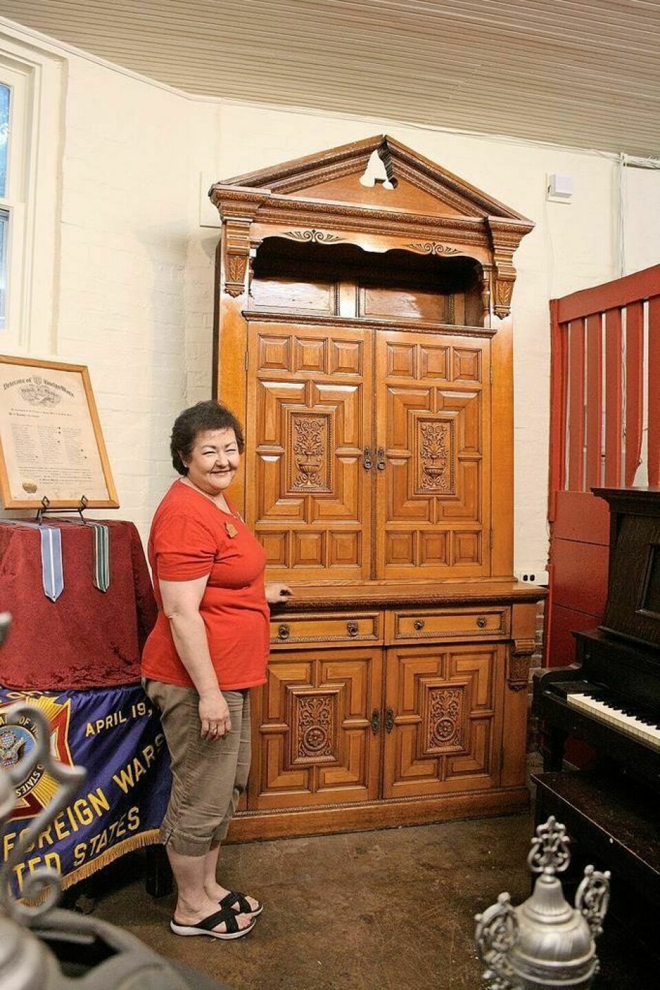 The bottom shelf, behind the photos, contains a secret panel. Historic cabinet from former Sam Reeves home on display