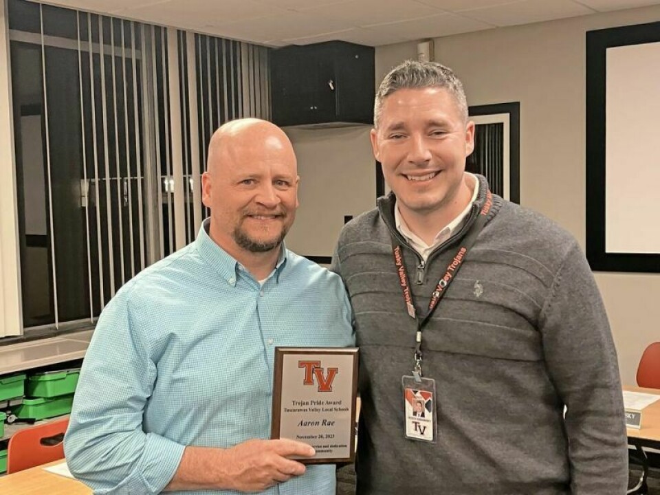 Pastor Aaron Rae of the Bolivar Community Church receives the Trojan Pride award, left, standing with Superintendent Derek Varansky. Community thanked for their support