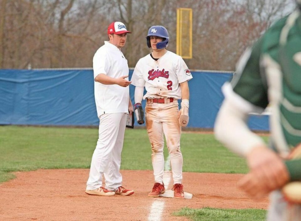 West Holmes coach Wyatt Mellor discusses strategy with Brock Gallion at third base. Despite getting drilled in the face by a pitch for the second time this season, Gallion stayed in the April 9 game and helped the Knights earn an 8-0 win over OCC rival Madison. West Holmes baseball blanks Madison
