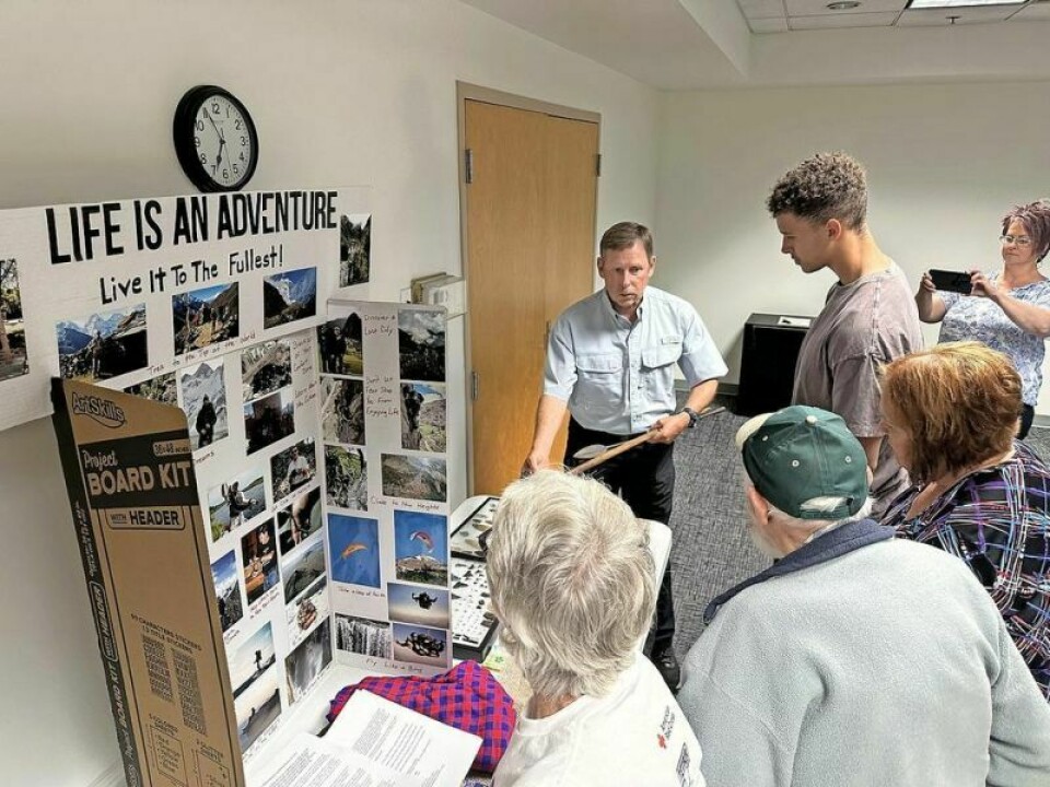 Larry Compton, back, discusses some of the memorabilia he has collected over his years of exploring nature, whether it’s climbing mountains, deep sea fishing, cave exploration or sky diving. Compton spoke at the Holmes County District Public Library recently, taking visitors on a virtual one-hour video trip of Mt. Everest. Compton inspires others to embrace the spirit of adventure