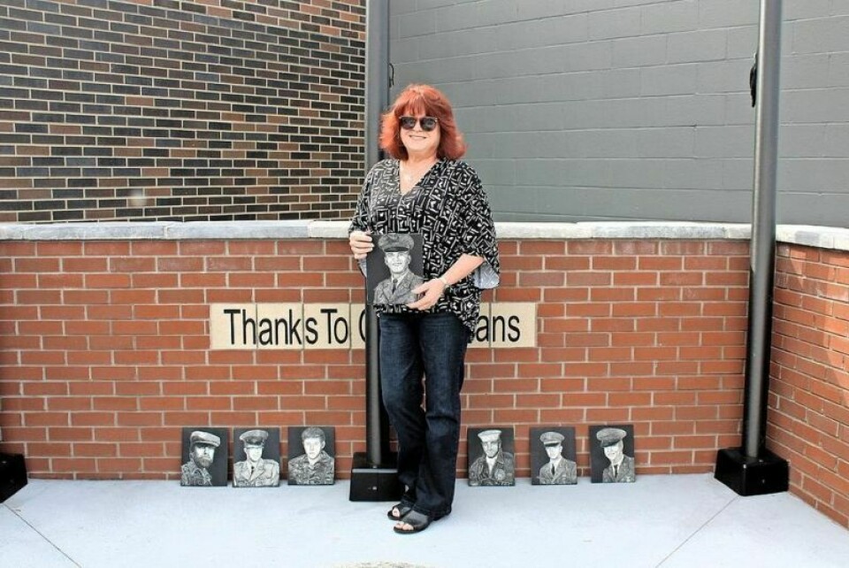 Artist Vivian Mosley with some of the portraits she’s created to honor Vietnam veterans at the memorial outside the Tuscarawas County Veteran Services office in New Philadelphia. Local artist honors Vietnam veterans with portraits
