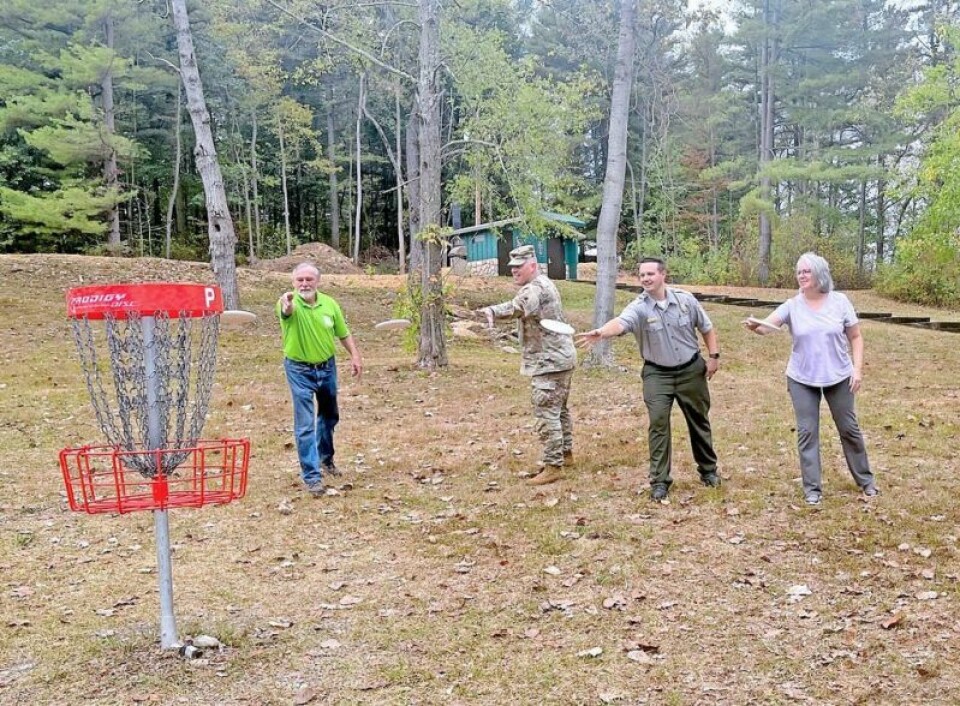 Bill Griffith, left, course designer, is joined by Col. Jayson Putnam and Hunter Simmons of the U.S. Army Corps of Engineers and Linda Chen of the Stark County Audubon Society in a ceremonial disc toss to officially open the Beach City Dam Disc Golf Course. Disc golf course opens at Beach City Dam