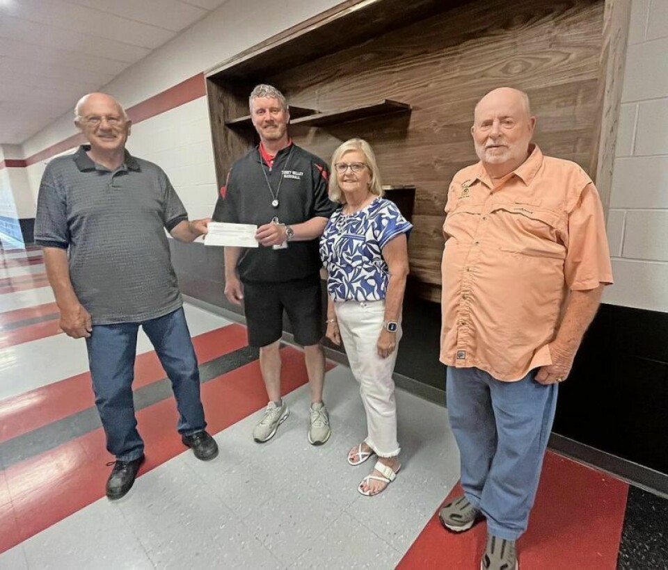 Members of the Tusky Valley Class of 1964 present a check to Principal Jason Phillips for a trophy case at the new middle-high school: Don Miller, left, Phillips, Tana Lake and Dillon Hickman. One section of the case is mounted on the wall while the remaining pieces are being built. Class of 1964 donates trophy case