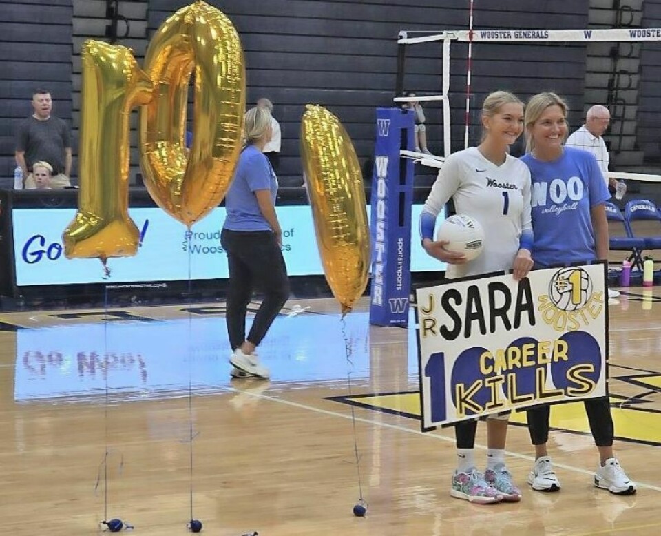 Wooster High junior Sara Snowbarger, left, stands alongside her coach and mother Jen Snowbarger while being celebrated for reaching 1,000 kills in a recent match. The younger Snowbarger has committed to play collegiately at Indiana. Snowbarger becomes first General to reach 1,000 kills