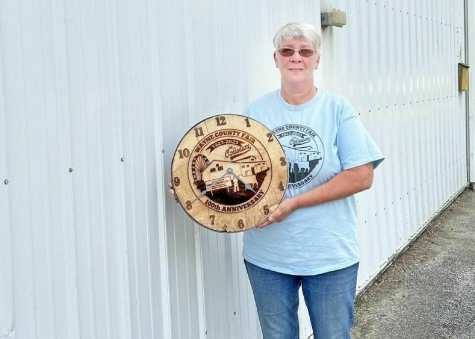 Lisa Gress displays one of the clocks made to commemorate the 100th anniversary of the Wayne County Fair Coliseum. Gress and her husband Joe had 12 of the clocks — which will be auctioned off prior to the junior fair auctions and designated shows at the fair — made from some of the cypress trees removed to make way for the Wayne County Event Center. Coliseum’s 100th year a chance to celebrate, remember