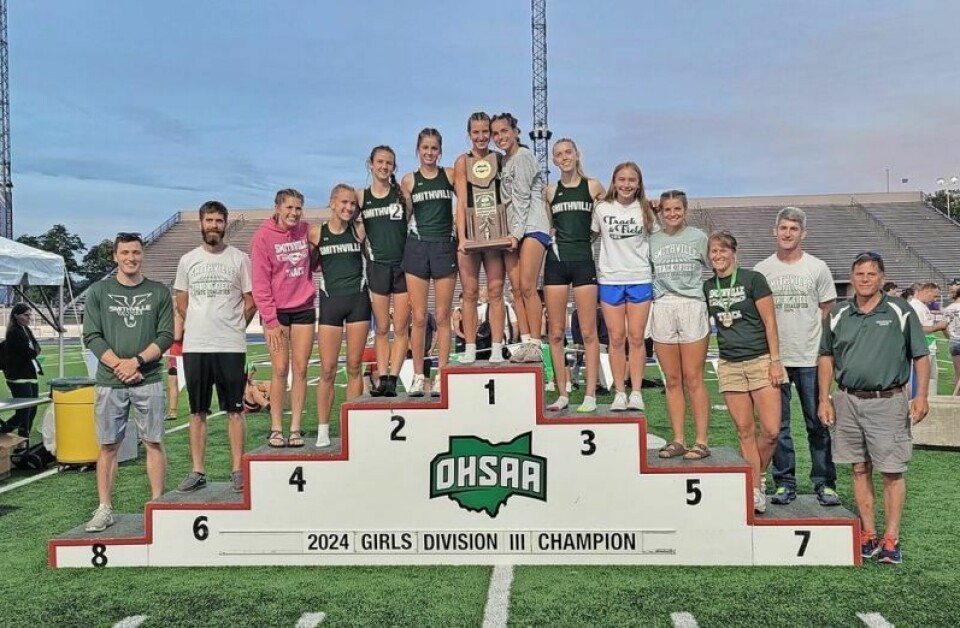 Smithville’s girls track team and coaches pose on the podium after capturing the program’s first state title at the OHSAA Division III State Championships. Smithville girls win Div. III state track championship