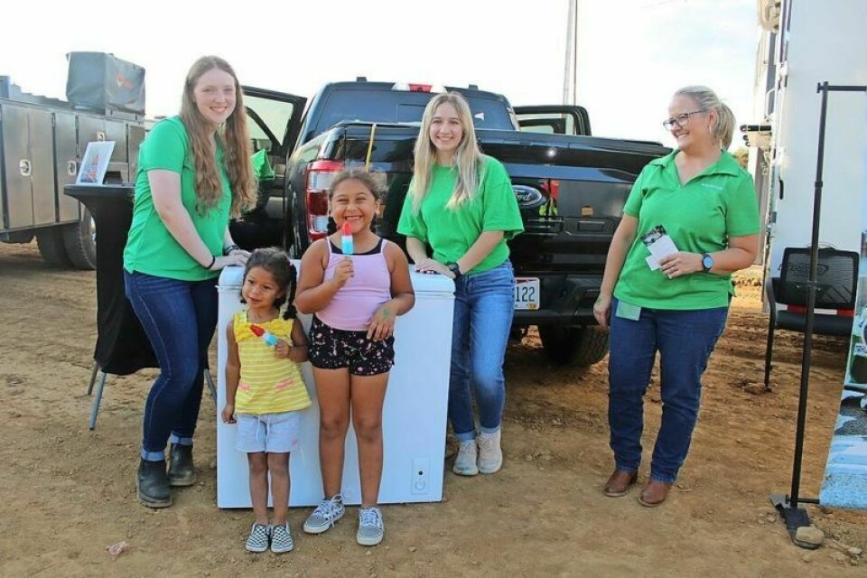Francesca Gangale, 3, and her sister Giavanna, 6, of Dover enjoy Popsicles from a freezer powered by a hybrid truck that contains parts made by the Schaeffler Company. Schaeffler employees Callee Barker, left, Heather Wolfe and Rhonda Longo were on hand to help pass out the treats. Schaeffler Co. participates in first community event at fair