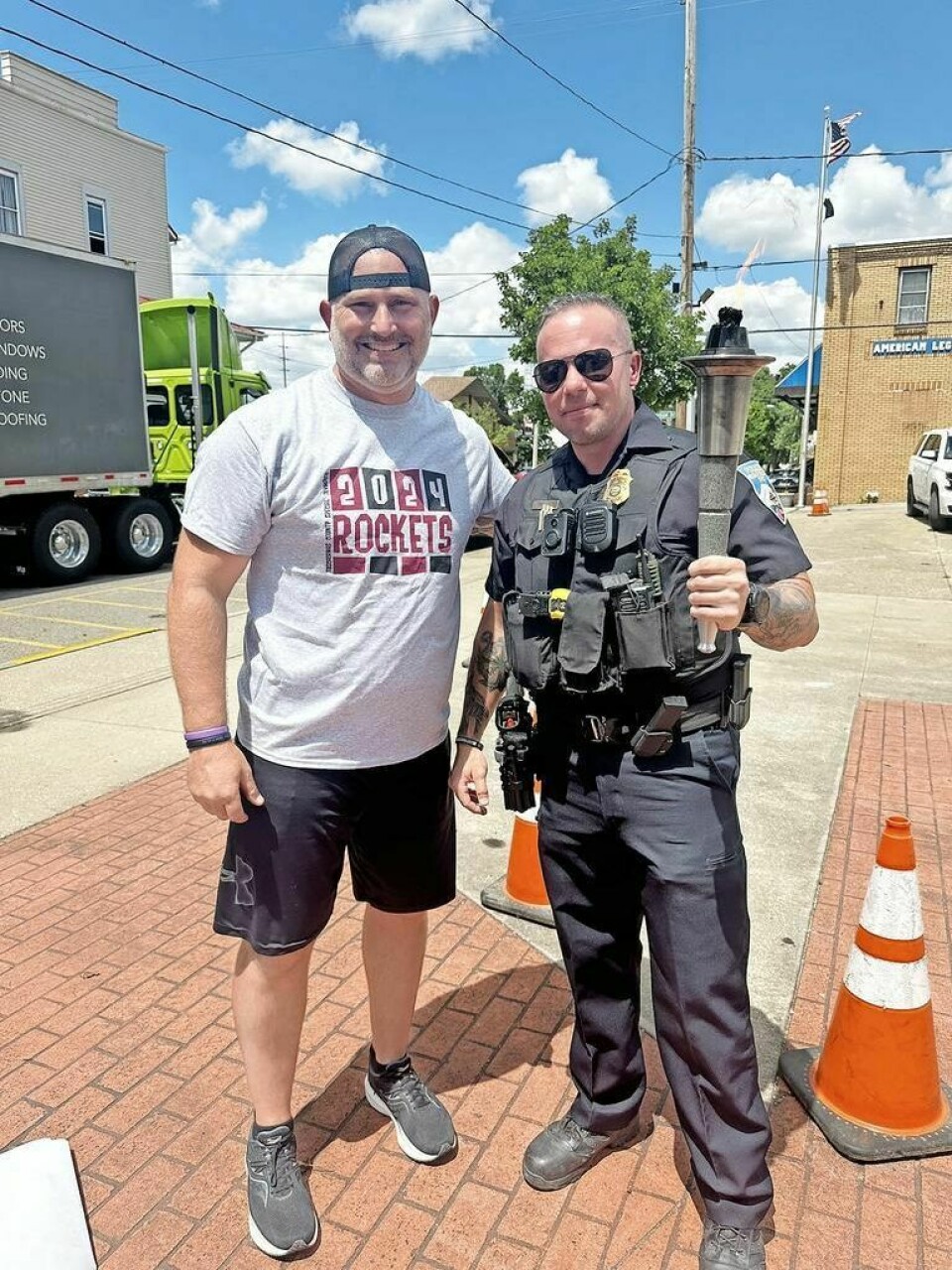 Brian Dalton, assistant chief of police with the Sugarcreek Police Department, right, joins Ohio LETR organizer Nathan Samples, who also is an officer with the Doylestown Police Department, at the Torch Run stop in Sugarcreek on Thursday, June 27. Police honored to support Special Olympics Torch Run