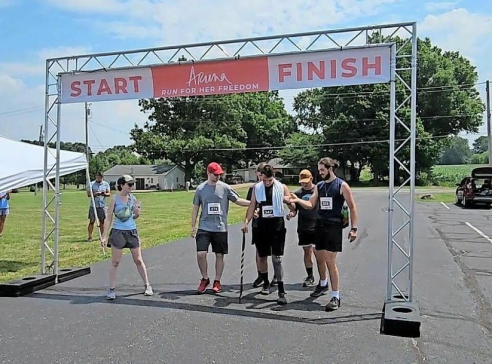 Bradie Ramella, middle, finishes the recent Aruna 5k race in Dalton. Ramella did so despite his continued recovery from a brain injury and with a prosthetic leg, both as a result of a 2022 motorcycle accident. Local man recovering from accident finishes Aruna 5k