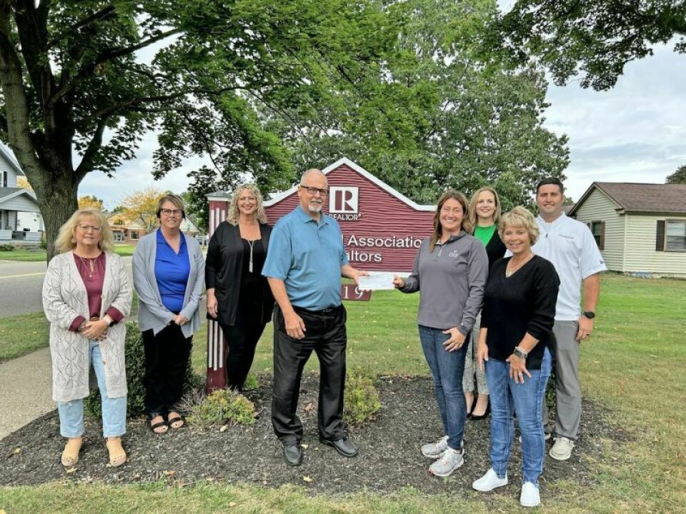 Amy Myers, left, Jody Clark, Stephanie Glazer, Greg Norris, Kelly Rager, Mary Hogue Scott, Traci McConnell, and Cory Parker. Blessings in a Backpack receives local donation