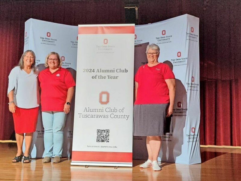 Ranz-Calhoun, left, Shaw and Campbell with the banner the club received. Local group is named 2024 OSUAA Club of the Year