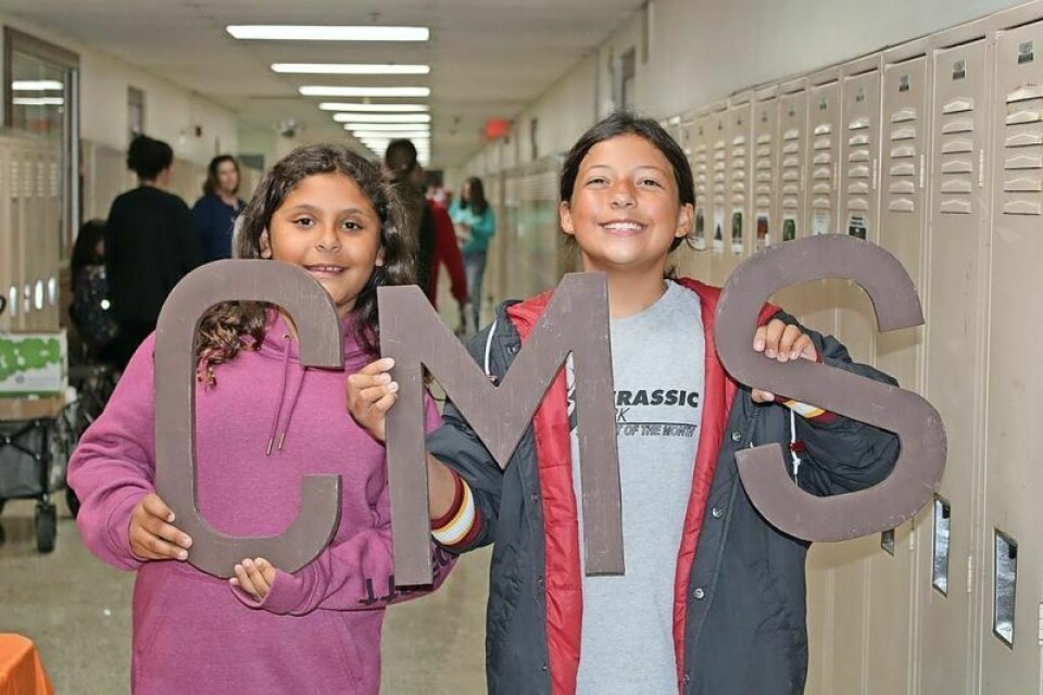 Mianna Garcia, left, an elementary student, and her cousin Kendall Meese, a student at Claymont Middle School, show their school pride at the Mustang Mania event. Event transforms students and families