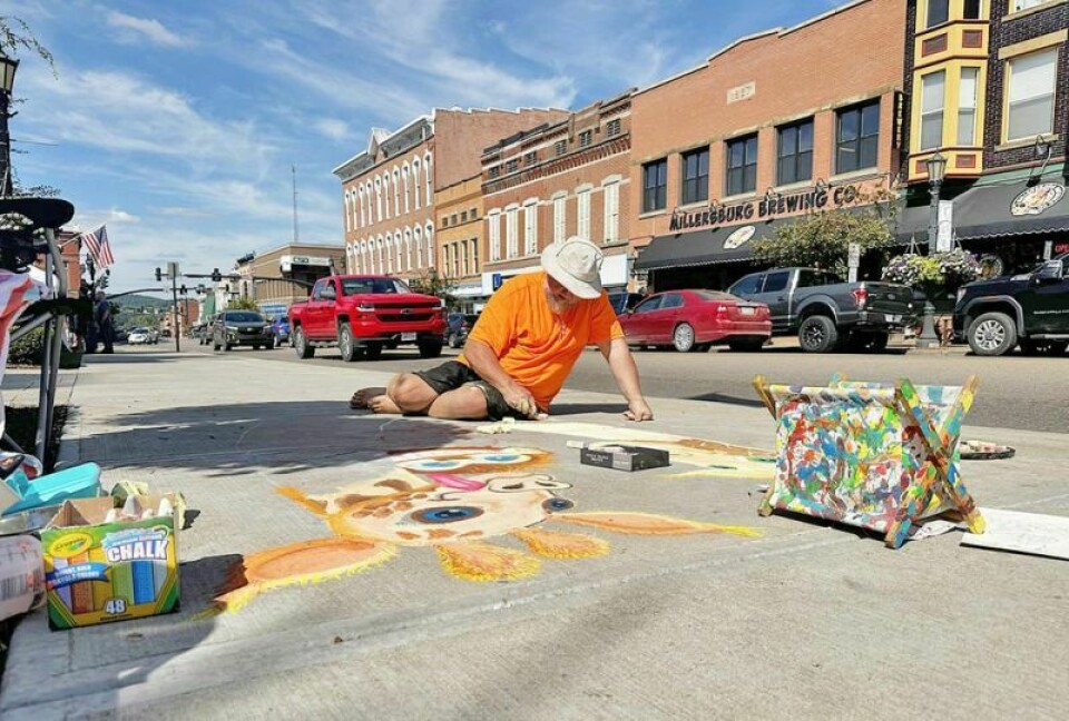 Sidewalk chalk painter Dan Cherney plopped down along Jackson Street and began creating a playful picture of two giraffes and a monkey during Arts in the Burg on Saturday, Sept. 16. Creativity takes center stage during Arts in the Burg