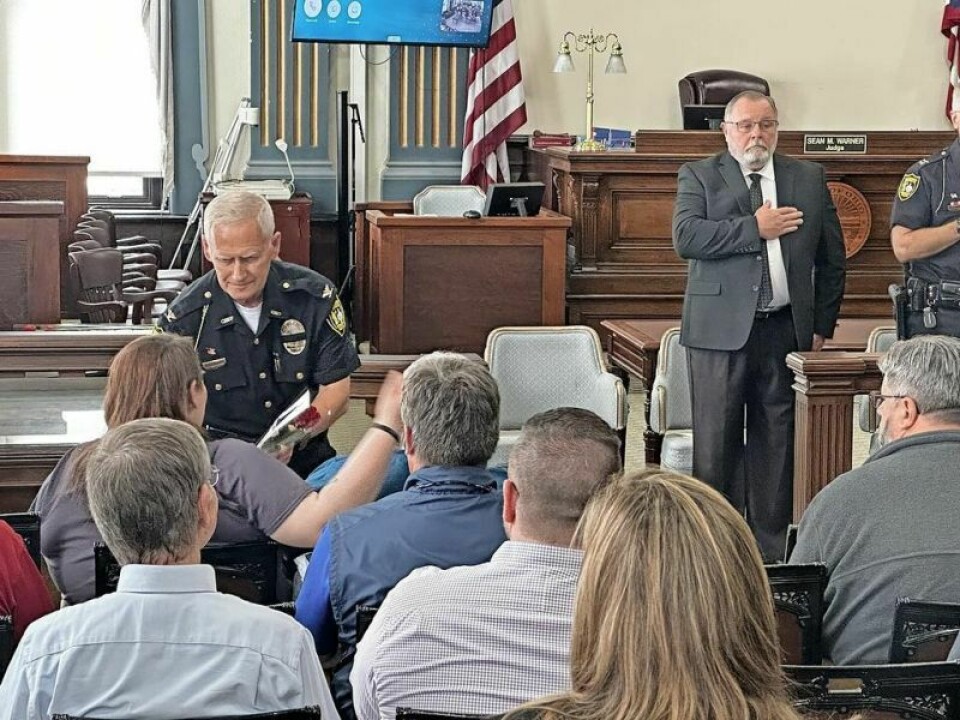 Retired Millersburg Police Chief Thomas Vaughn presents loved ones of officers who passed away in Holmes County with flowers in their honor during the May 17 Holmes County Ohio Peace Officer’s Memorial Ceremony. Somber memorial honors slain officers