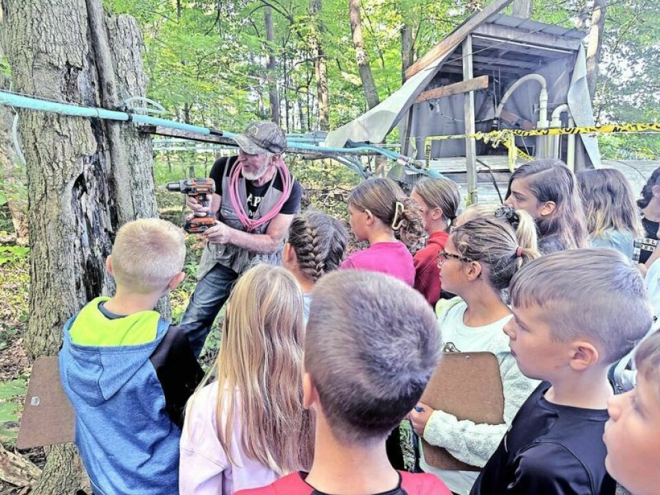 Ferman Wengerd, owner of Ayrdell Farm and Tap Tap Maple, shows a group of students how they drill into a maple tree to tap into the sap that will soon be boiled down into delicious maple syrup. Tap Tap Maple keeps the syrup flowing