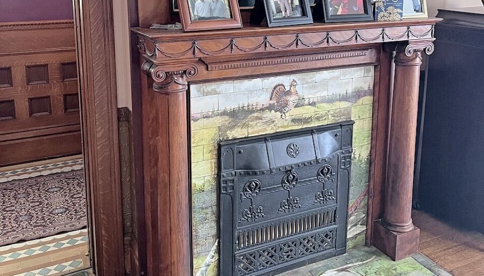 One of the original fireplaces featuring a hand carved mantel.